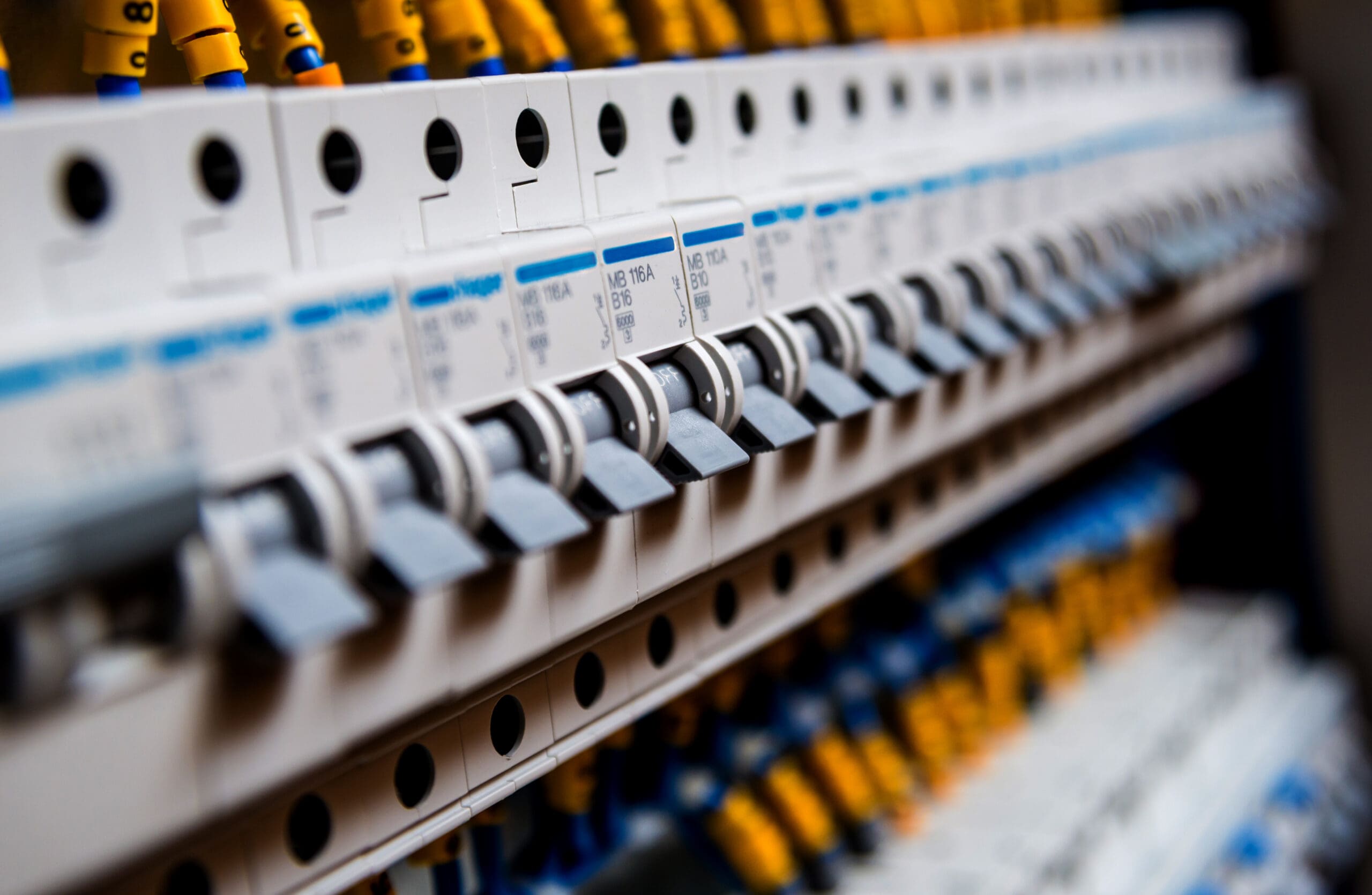 Close-up view of rows of circuit breakers with switches and wiring visible in an electrical distribution board.